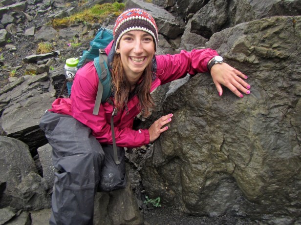 Figure 1: Author Amy Atwater next to a large hadrosaur track in Denali NP.