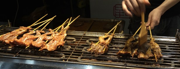 Grilled frogs on a stick are a tasty snack.