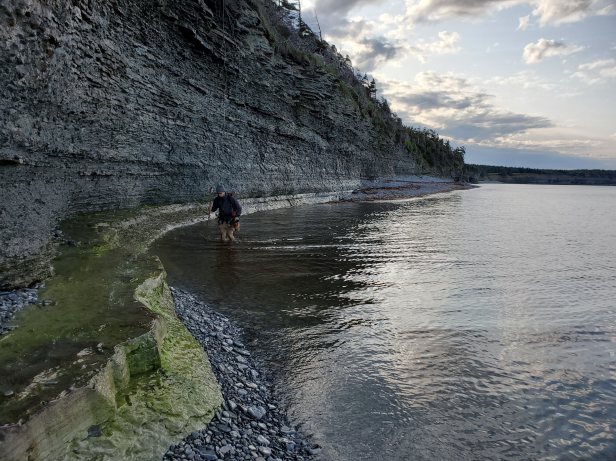 Traversing the Ordovician-Silurian boundary section on the eastern coast of Anticosti Island (Québec, Canada). In this remote location, the fossil and stratigraphic are exposed in towering coastal cliffs that provide continuous access to outcrop.
