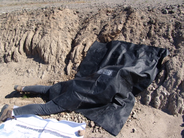 hannon Mahan hiding beneath a black cloth. "It looks funnier than it is," she noted. "Being under that black cloth in the Mojave can give you heatstroke, but in order to collect samples for my geologic specialty, I sometimes have to protect them from light."

